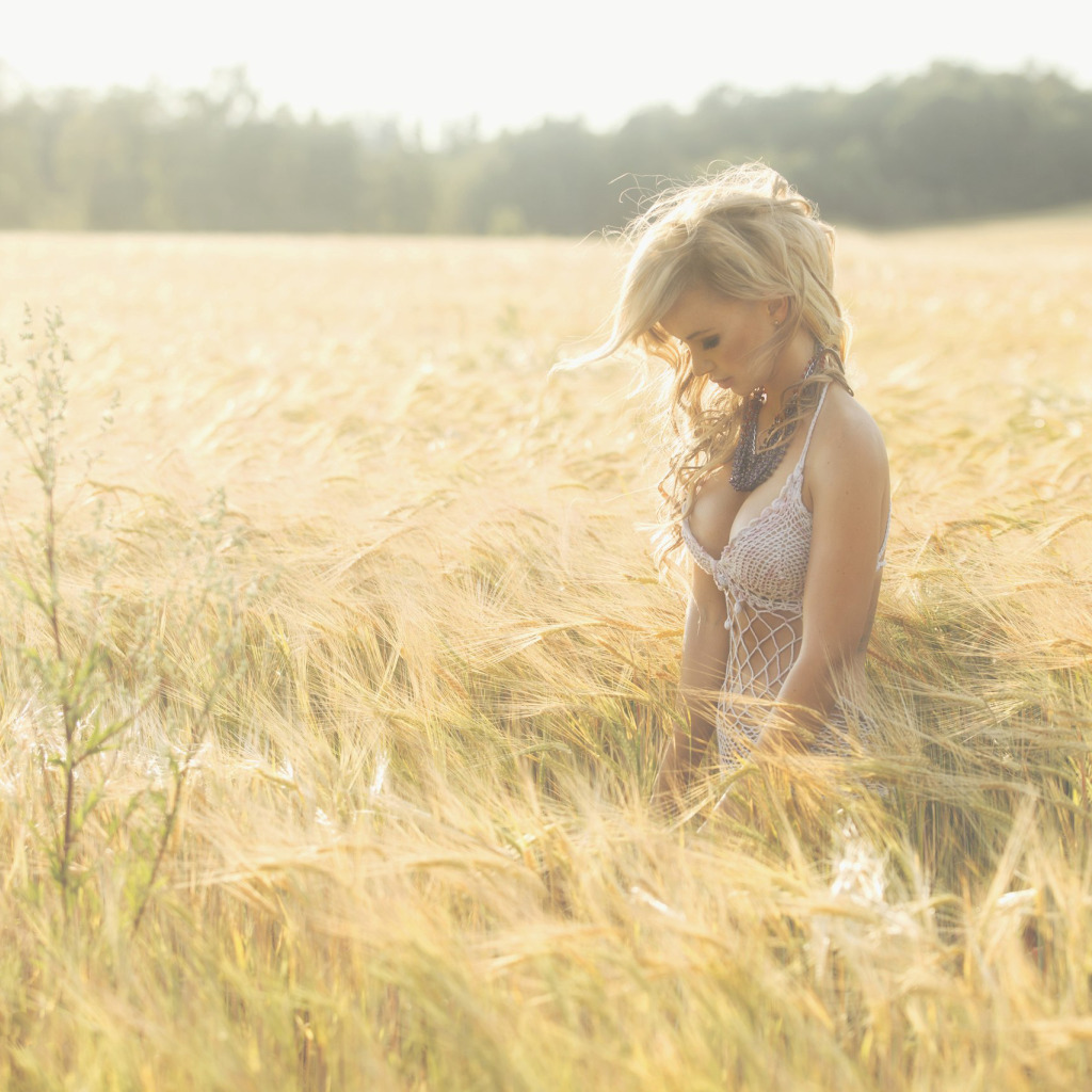Загорелая девка позирует голышом в поле с соломой